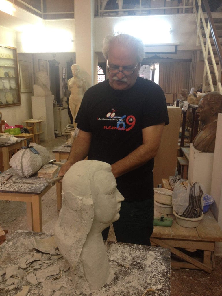 sculptor man modeling a plaster bust at 'Domaine Anagennisi' workshop