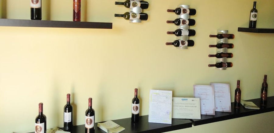 wine bottles on the wall fixed in horizontal position at 'Domaine Mitzifiris Bio Wines' facilities