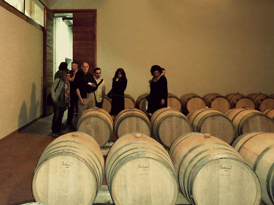 tourists visiting the'Domaine Papagiannakos cellar with lying wood barrels