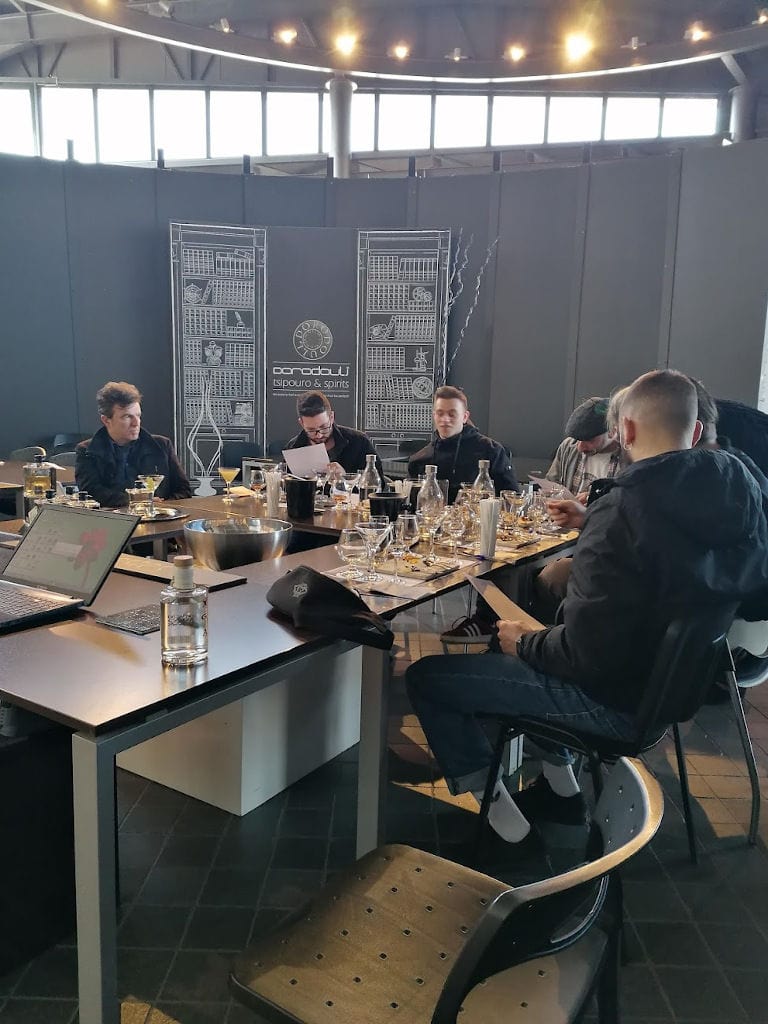 Tourists sitting at the table and eating and enjoy a tasting at 'Dorodouli Tsipouro'