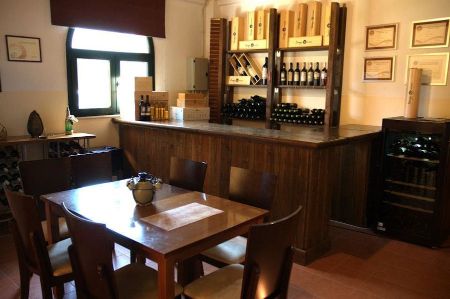 wood table with chairs into 'Dougos Winery' wine tasting room