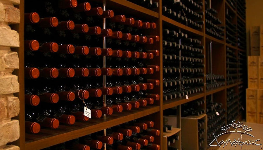 wine bottles in horizontal position in the storage locker at Douloufakis Winery cellar