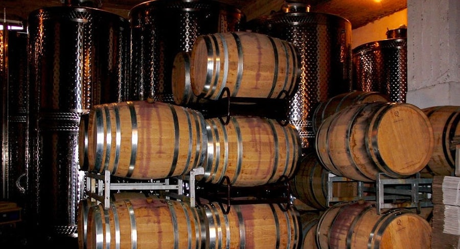 wine wood barrels on top of each other at Douloufakis Winery cellar