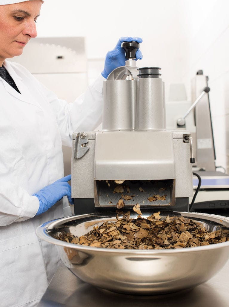 woman using a machine to cutting truffles in slicers at 'Dryas Greek Truffle' plant