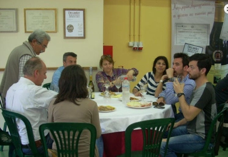 a group of tourists sitting and drinking and eating at Efrosini Winery