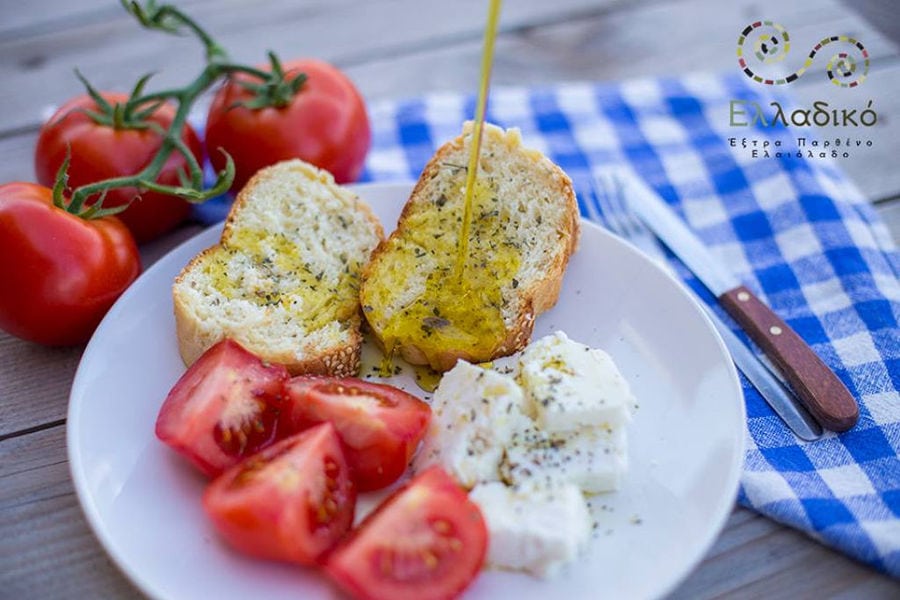olive oil flowed on slices of bread at Elladiko and tomato cutting and cheese at 'Elladiko'