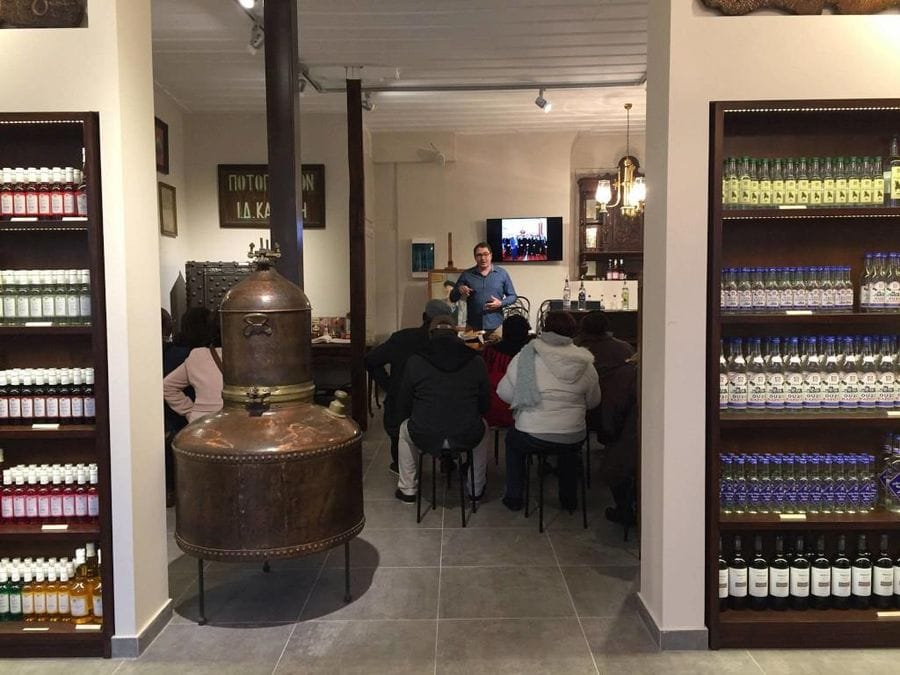 entrance with lockets and tourists listening to a guide at Karonis Distillery–Gastronomy Tours
