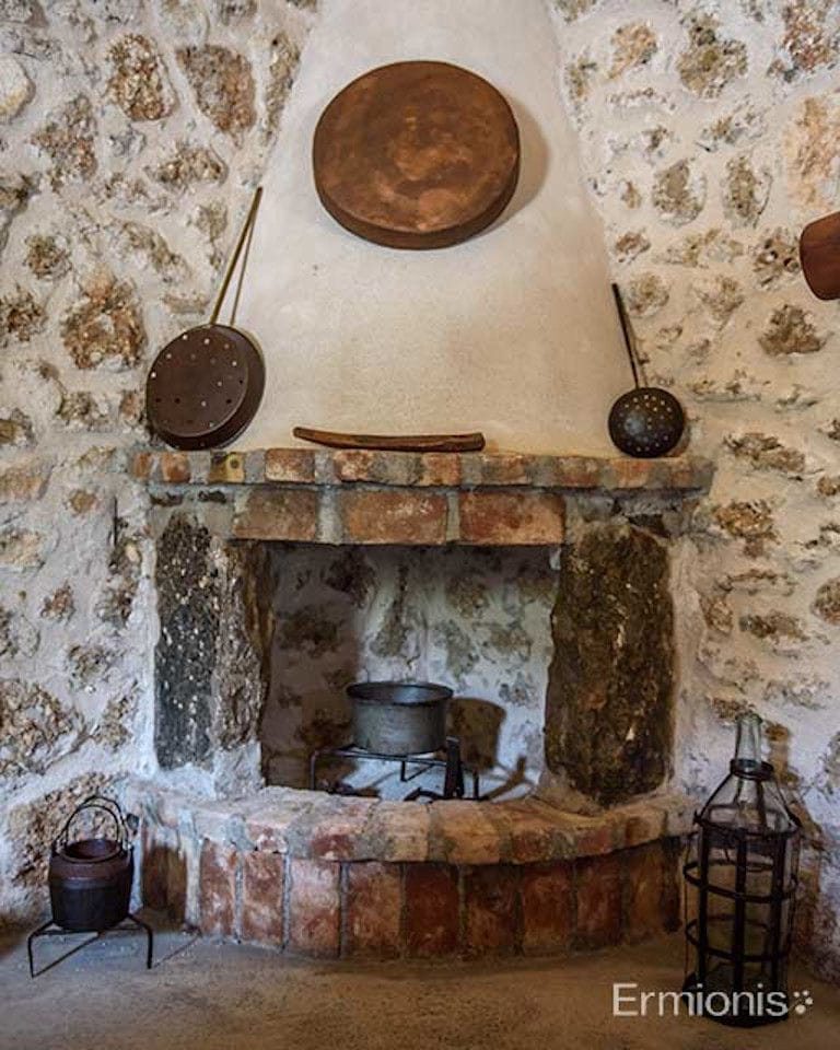 stone fireplace with tin utensils at 'Olive Oil Museum, Ermionis Bairaktaris Apiary'