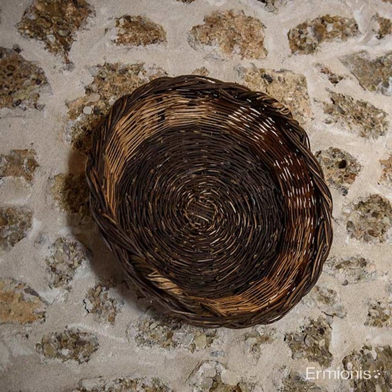 empty straw basket on stone floor from above at 'Olive Oil Museum, Ermionis Bairaktaris Apiary'