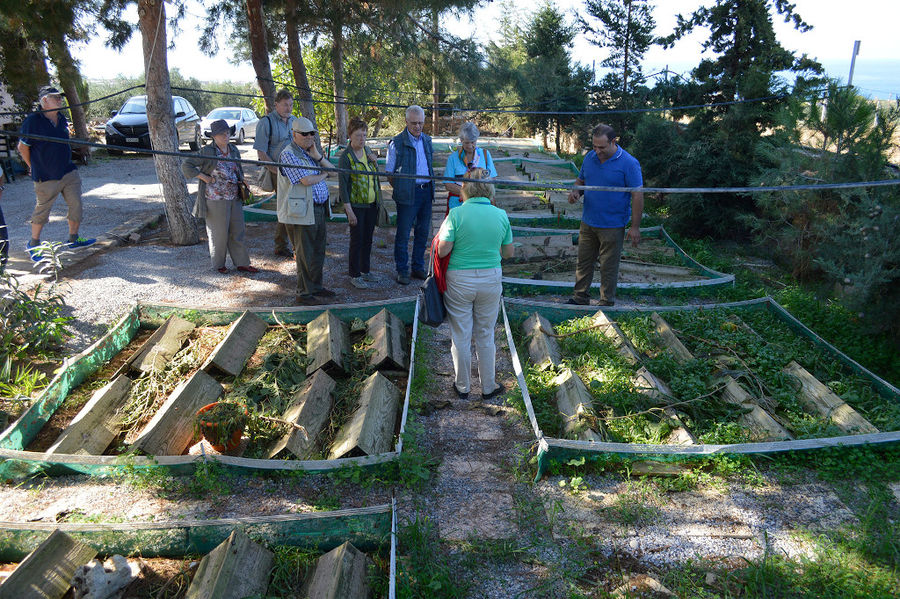 a group of tourists listening to a man giving a tour at Escargot de Crete farm outside