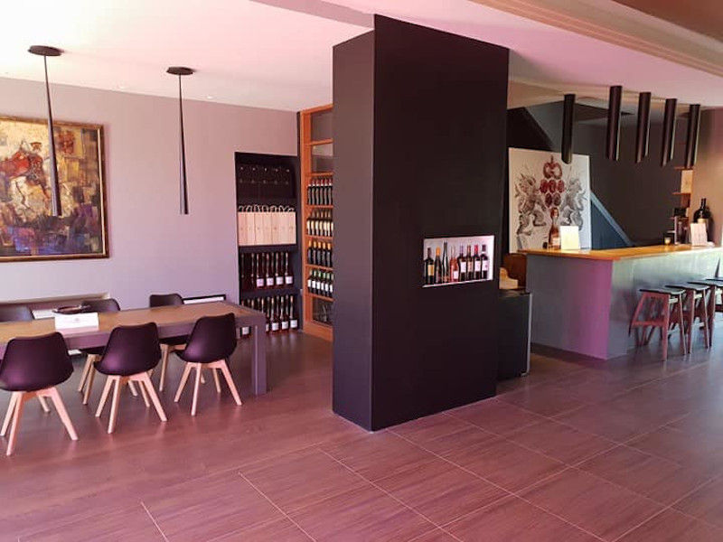 Constantin Gofas Estate tasting room with wood table and wood reception and a wall in the center of area