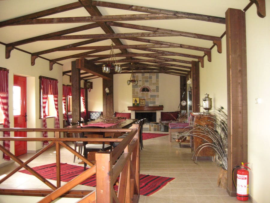 folklore living room with carpets and stone sofa and fireplace at 'Evritika Kellaria' winery