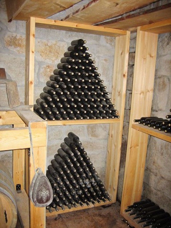 wine bottles on top of each other storaged in the stone wall in 'Evritika Kellaria' cellar