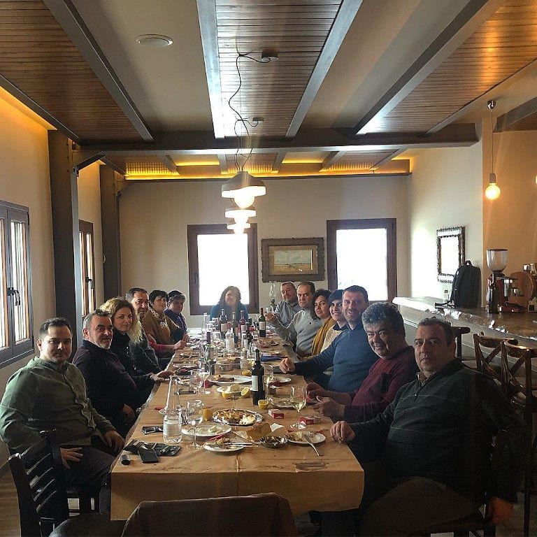 tourists smiling happily at the camera, eating and tasting wine at 'Filia Gi'