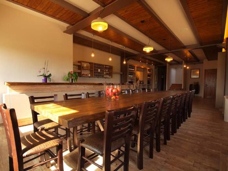 illuminated 'Filia Gi' tasting room with wood tables with chairs