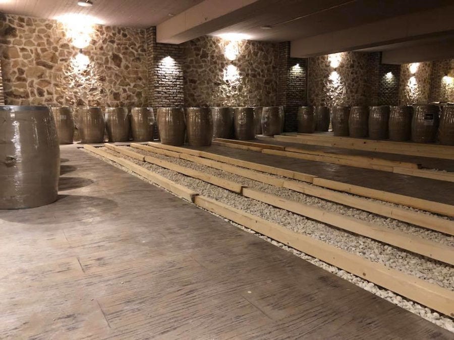 wine wooden barrels by the wall of illuminated 'Filia Gi' stone cellar