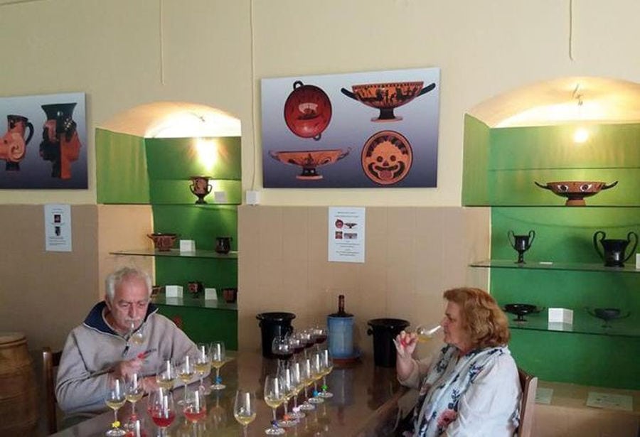 a couple sitting at the table and tasting wines at 'Domaine Foivos'