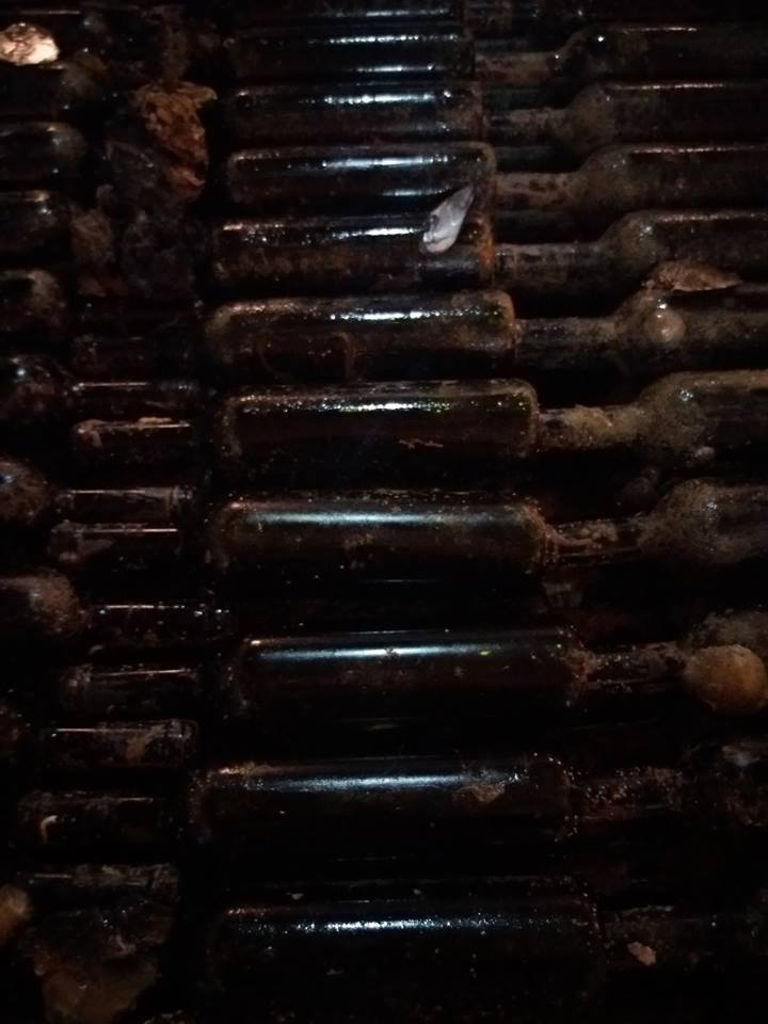 stacked wine bottles dirty with sea mud on top of each other at 'Domaine Foivos' winery