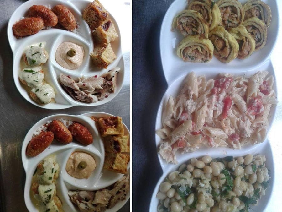 view from above of plates with spreads, pasta, fried fillets, legumes, omelette roll with smoked trout and pastitsio at 'Fresko'