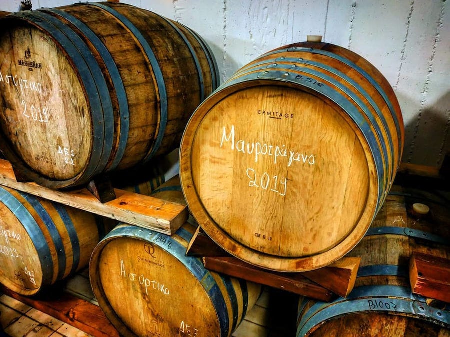 lying personalized wooden wine barrels sign with the Gavalas Winery logo into the cellar