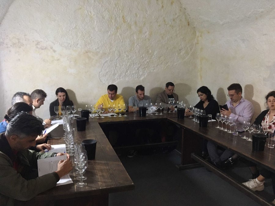 Tourists sitting at the tables and enjoy a wine tasting at Gavalas Winery