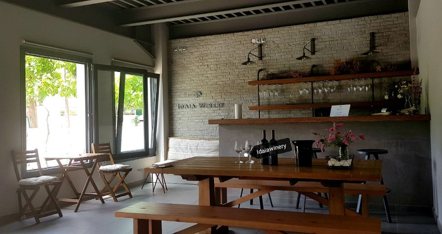 wine bottles on the wood table with benches in Idaia Winery room