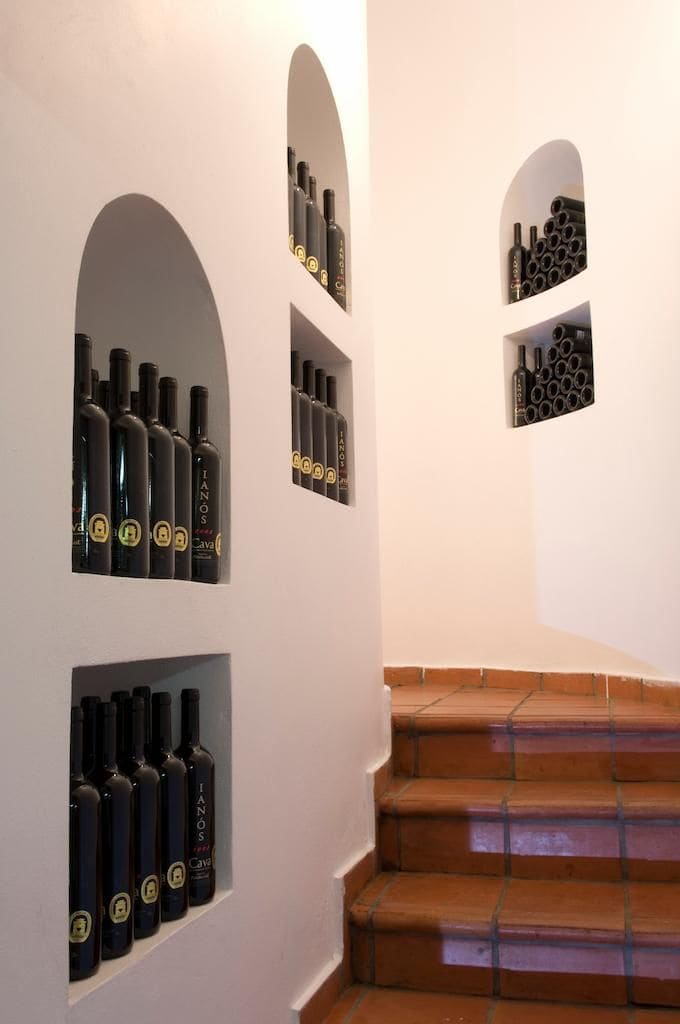 interior staircase with wine bottles stored in the walls on either side at Rouvalis Winery