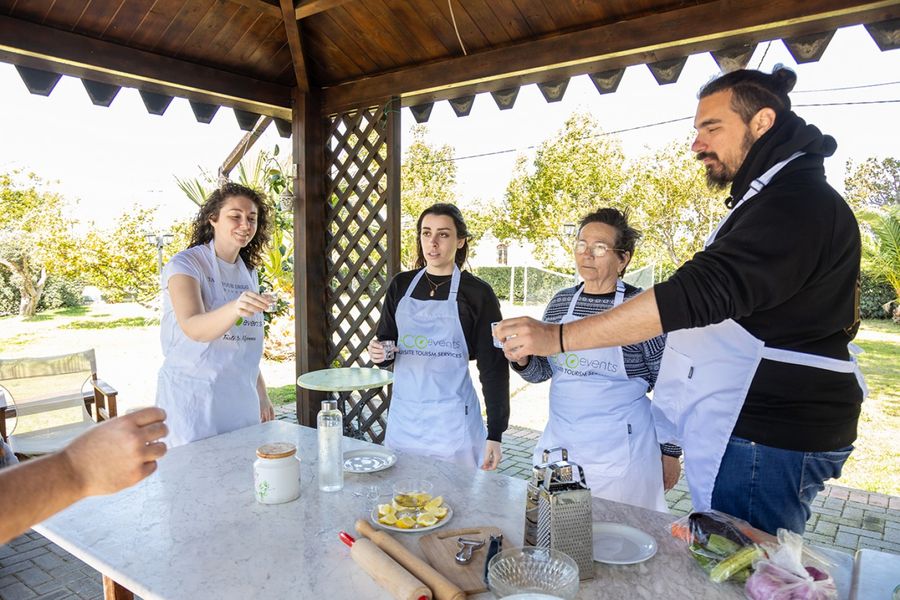 Four people share a moment of joy, raising shot glasses filled with tsipouro, their smiles and laughter capturing the essence of conviviality and the lively spirit of Greek traditions.