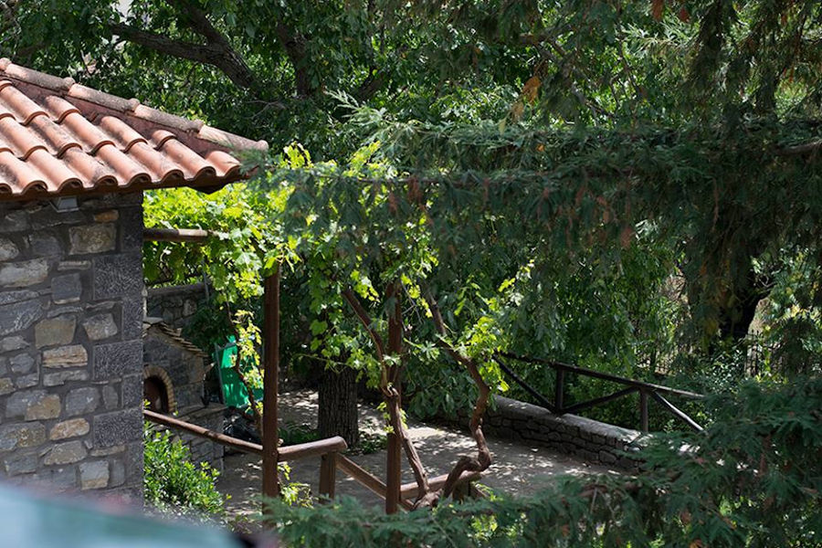 a corner of Kalogris Winery stone building surrounded by trees and plants