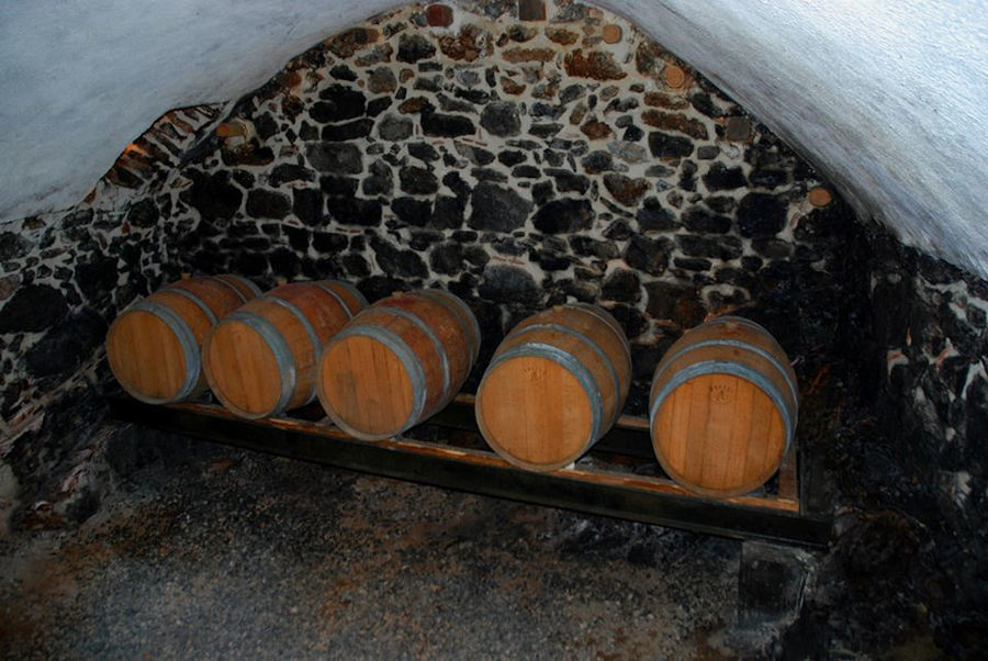 five small wood barrels in the stone wall of Kalogris Winery