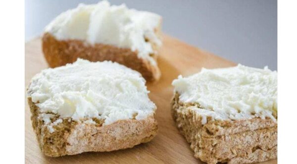 close-up of Greek ‘Katiki’ means a fresh and light soft white cheese spreading on three slices of dry bread