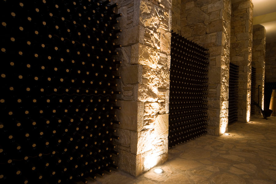 wine bottles on top of each other storaged in the stone wall in Kellari Papachristou cellar