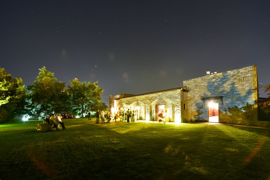 green lawn front the Kellari Papachristou winery illuminated by night