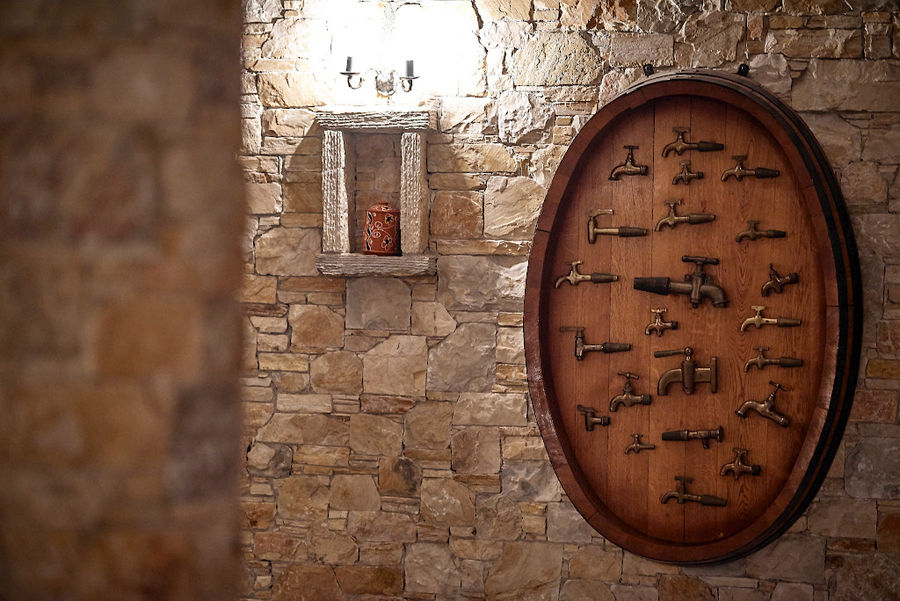 montaj on cover wood barrel of various bottle openers on Kellari Papachristou stone wall