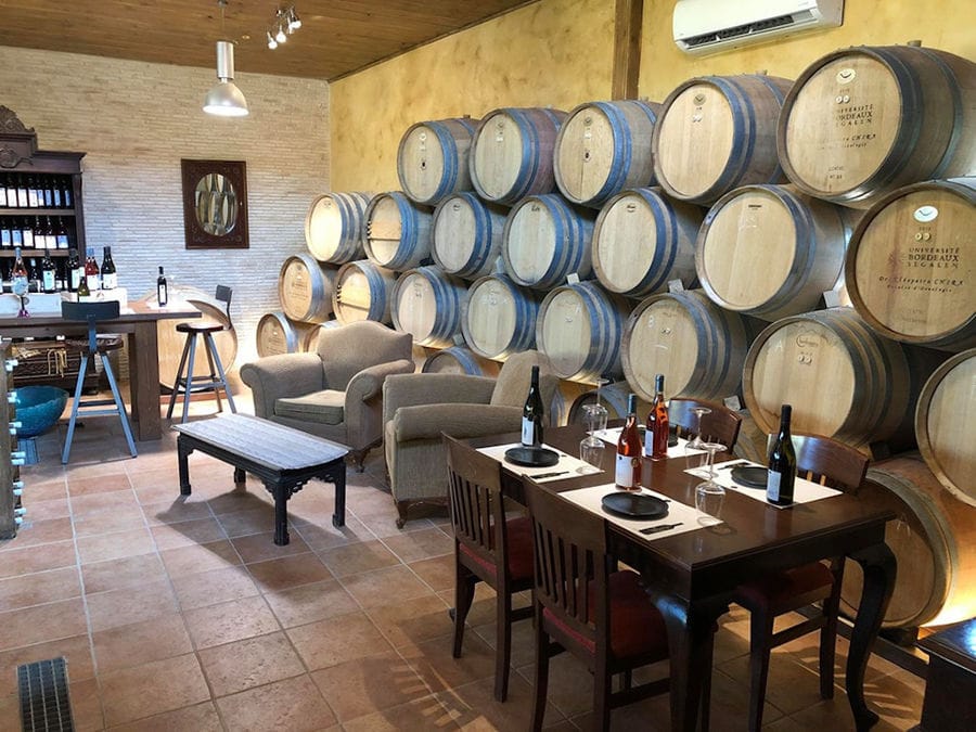 Klima Grampsa wine tasting room with wood barrels on top of each other on the wall
