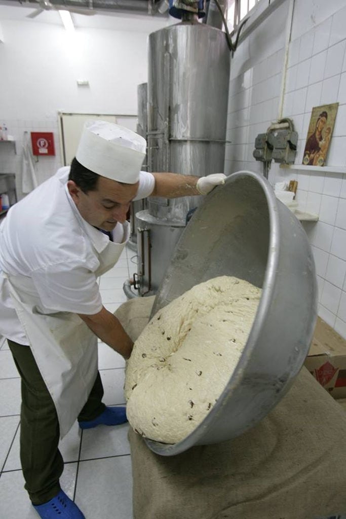 man with gloves mixing composition of Greek 'halva' in a basin at 'M. Kosmidis' workshop