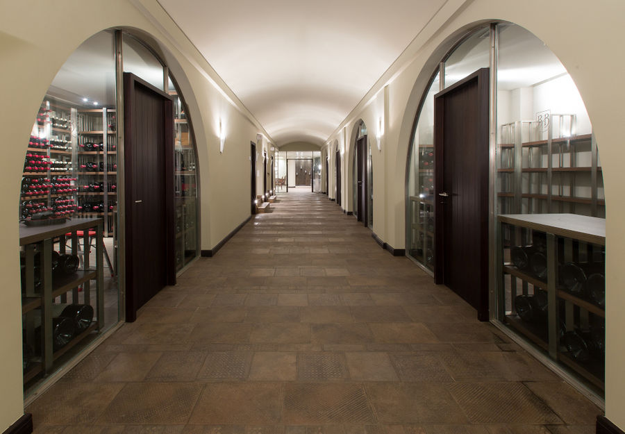 illuminated corridor of 'Ktima Biblia Chora' with arcades and wood doors on the bots sides