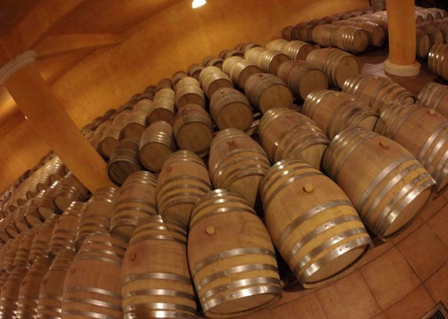 lying wooden barrels in a row at 'Ktima Karipidis' cellar