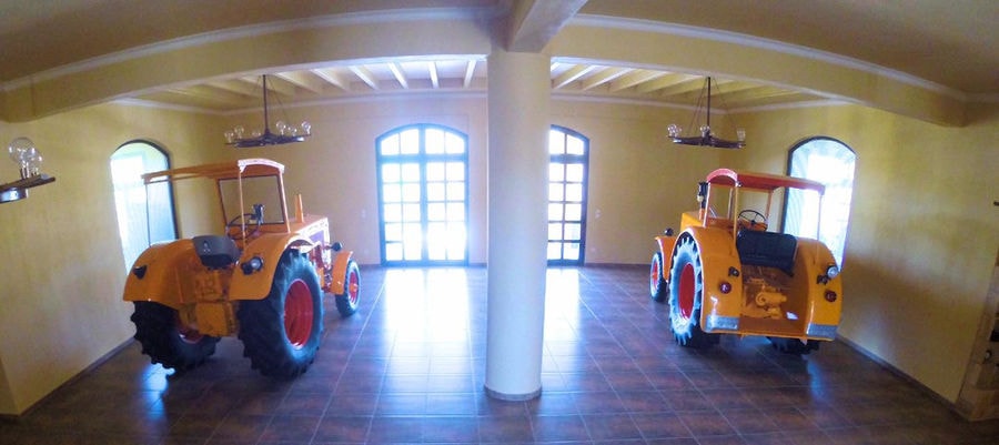 two tractors at illuminated 'Ktima Karipidis' room with natural light from the windows