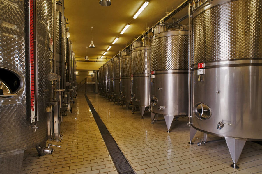 two rows of lying aluminum wine storage tanks at 'Ktima Karipidis' plant