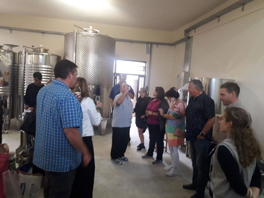tourists listening to a man giving a tour at Liepouris Winery area tanks