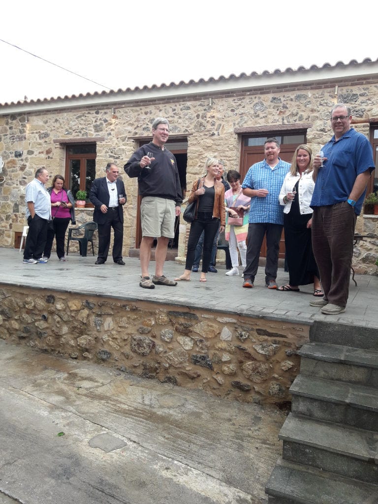 tourists smiling happily at the camera and tasting wine at Liepouris Winery outside