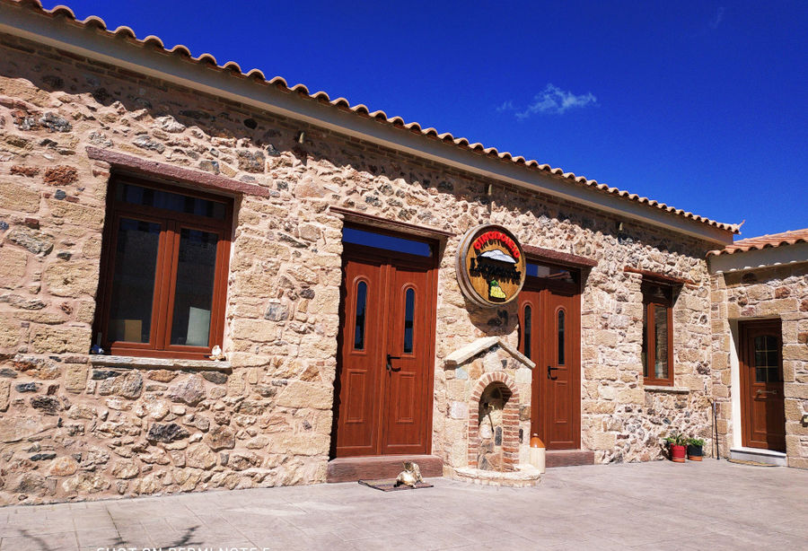 entrance stone building with a panel on the wall reprezenting Liepouris Winery logo