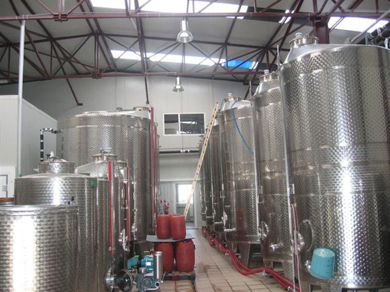 two rows of lying aluminum wine storage tanks at 'Limnos Organic Wines' plant