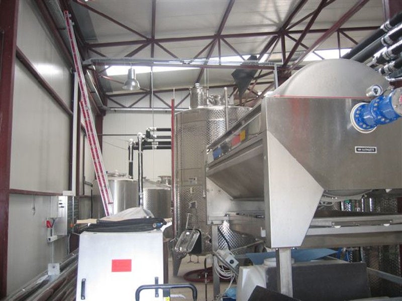 grape press machine and aluminum tanks at 'Limnos Organic Wines' plant