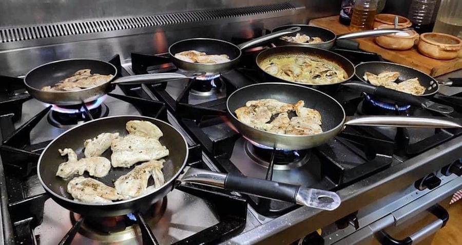 pans with various pieces of meat on the gas cooker to be fried at 'Lithies Organic Farm' restaurant