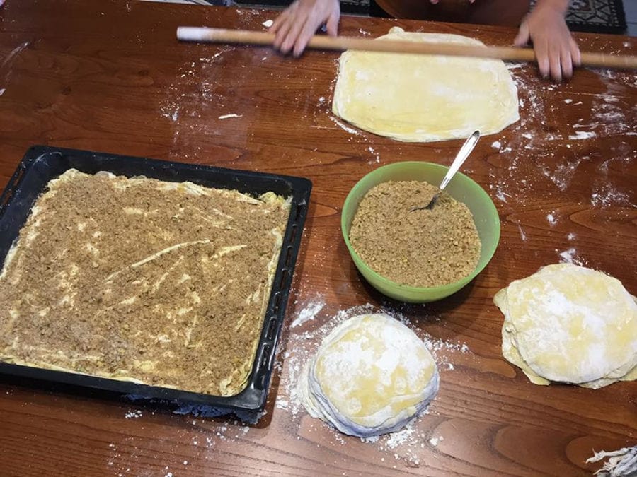 woman using wood dough paddles to make stuffed pie at 'Lithies Organic Farm' restaurant