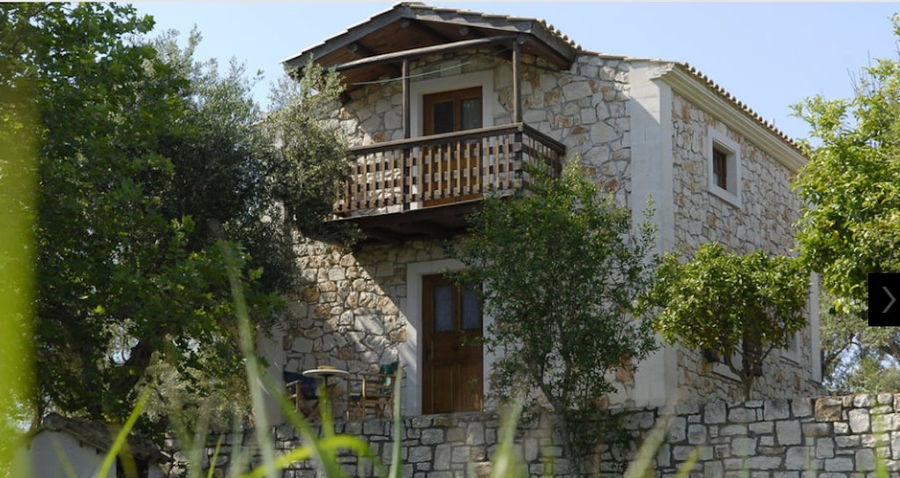 corner of 'Lithies Organic Farm' house surrounded by trees and green grass