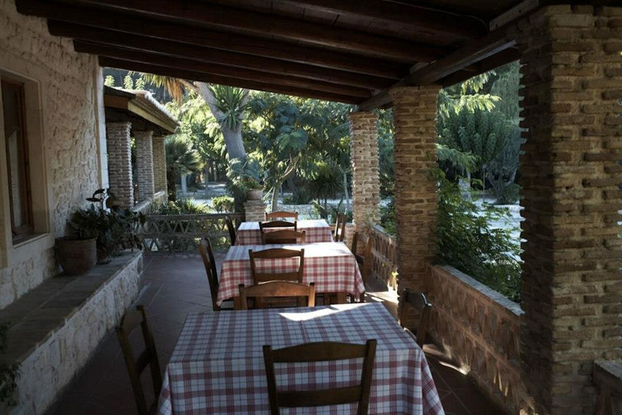 'Lithies Organic Farm' stone terrace with columns tables with chairs