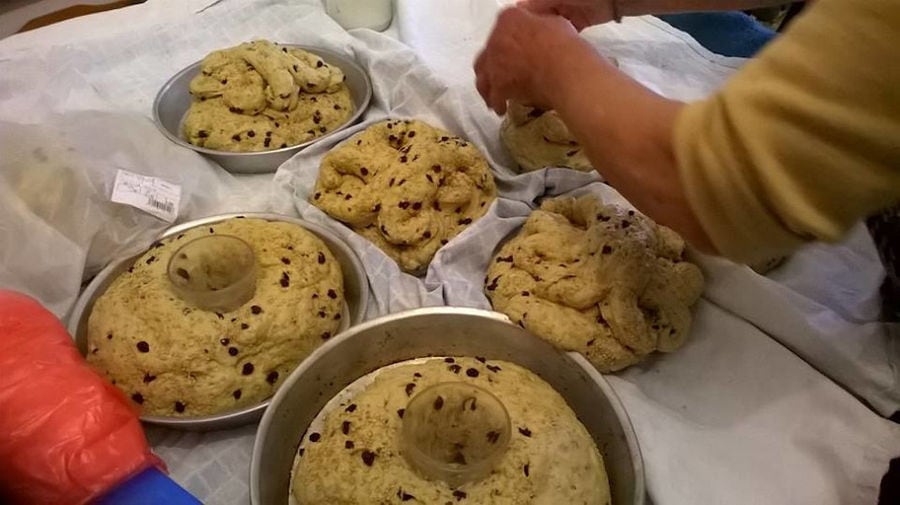 woman putting cake dough with raisins in round wases at 'Lithies Organic Farm' restaurant